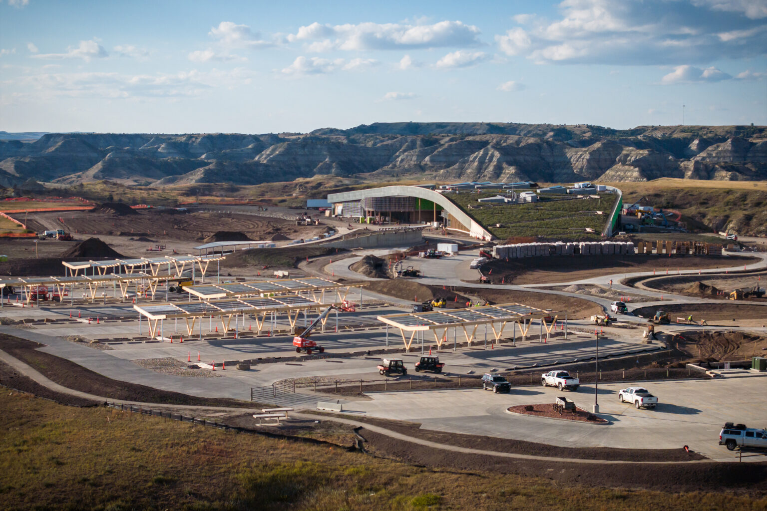 The Theodore Roosevelt Presidential Library under construction in the North Dakota Badlands, its curved concrete roof above the new concrete plaza